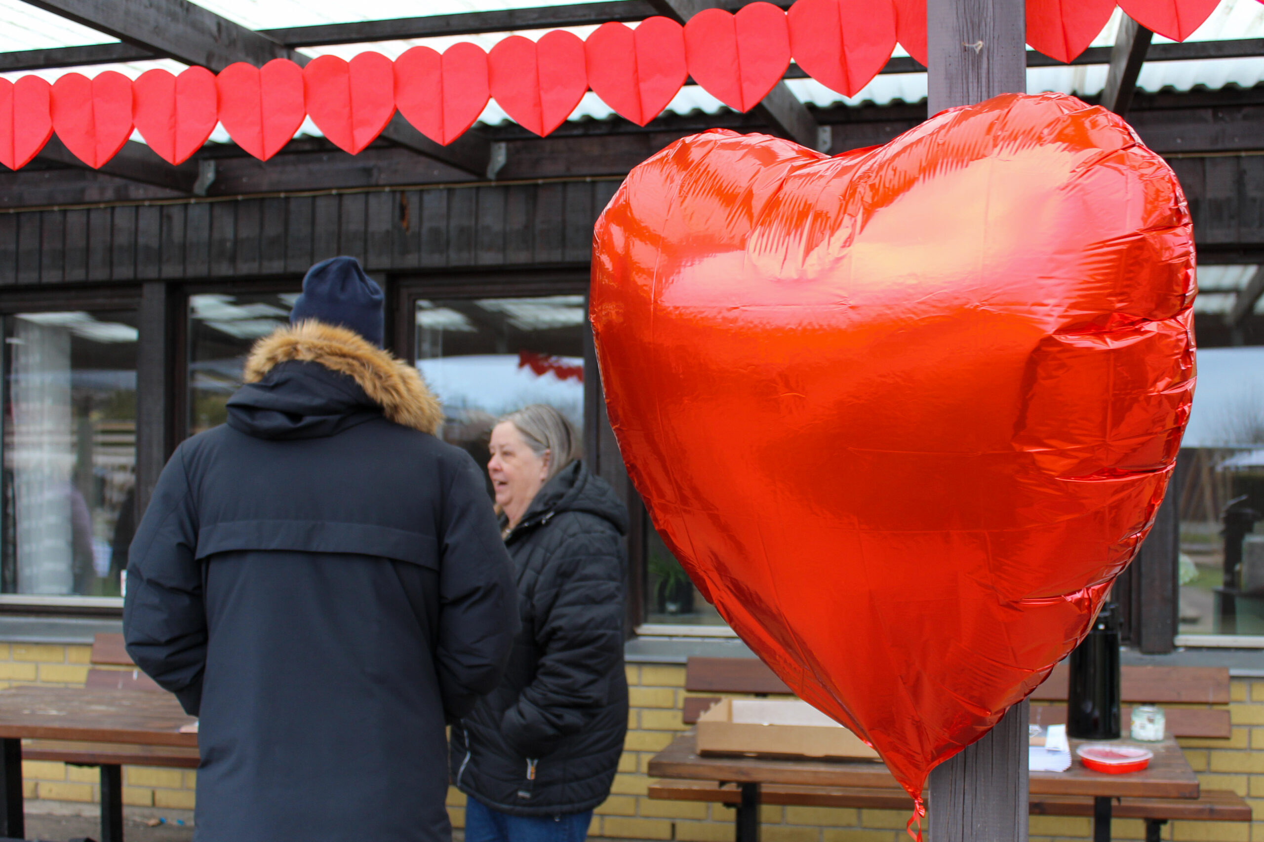 Ballong i form av hjärta och hyresgäst som pratar med förvaltare från Bjuvsfastigheter