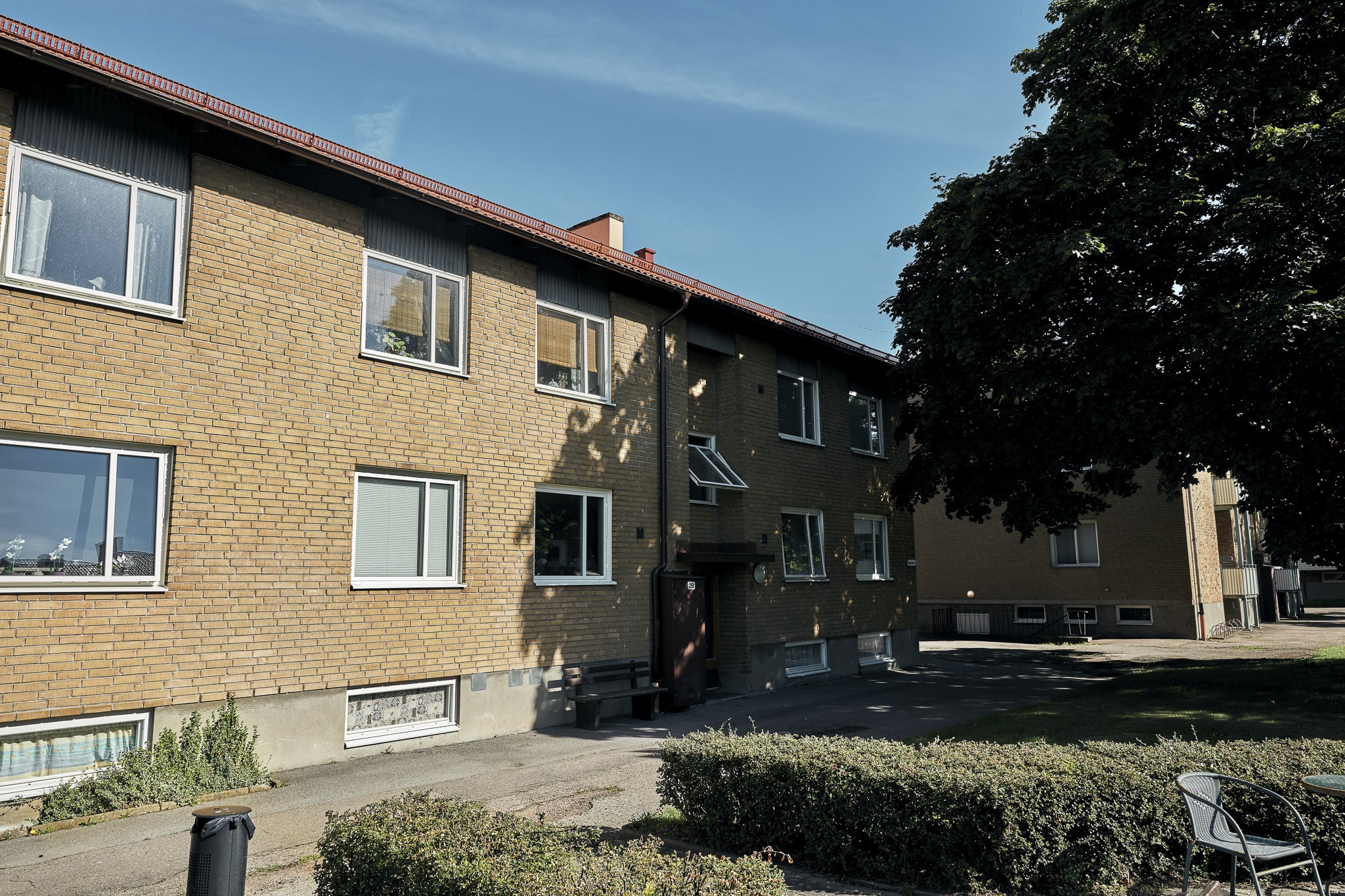 Nygatan 2 billsholm tvåvåningshus gult tegel med asfalterad gång , buskar och träd