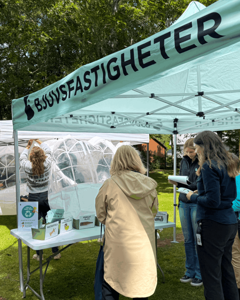 Besökare samlas vid Bjuvsfastigheters tält under Seniorfestivalen.