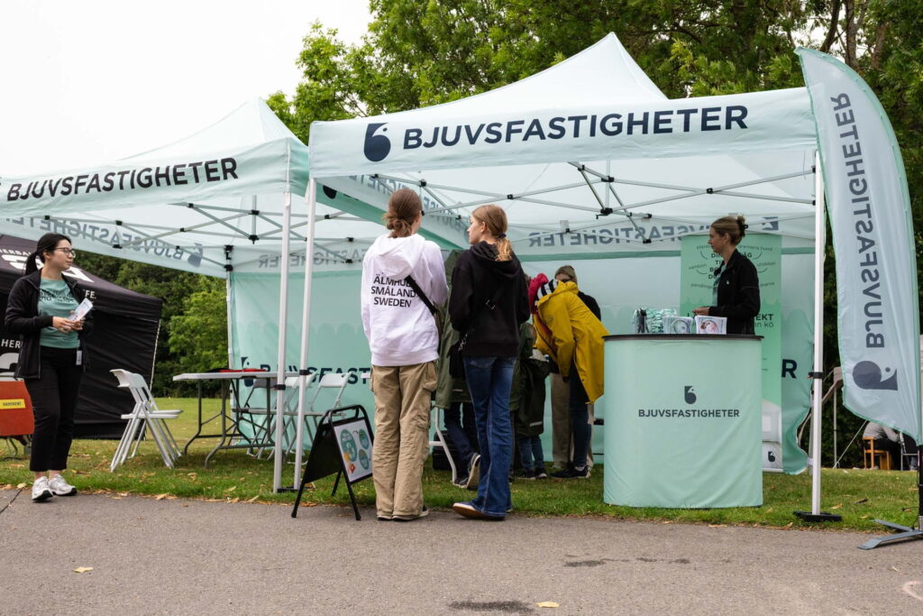 Besökare står vid Bjuvsfastigheters tält under Bjuvsfesten.