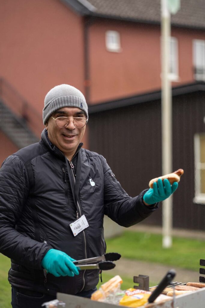Medarbetare från Bjuvsfastigheter grillar korv under områdesaktivitet på Akela.